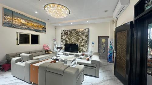 uma sala de estar com um sofá, uma mesa e uma televisão em Bald Cypress B&B em Lung-mu-ching