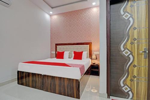 een slaapkamer met een bed met rode kussens bij OYO Hotel Moon Light in Zirakpur