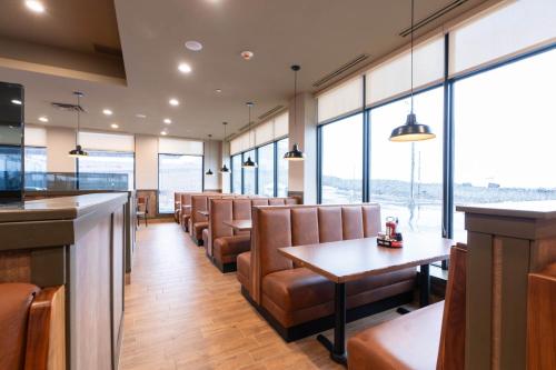 a restaurant with chairs and tables and windows at Sandman Signature Dartmouth Hotel & Suites in Halifax