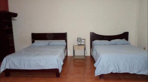 two beds sitting next to each other in a room at 31 ave home stay in Managua
