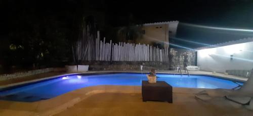 a large blue swimming pool at night at LE CHALET in Barranquilla