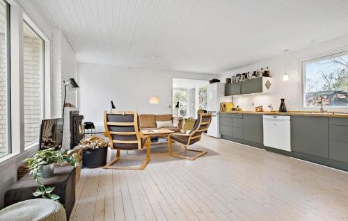 a kitchen and living room with a table and chairs at Nice Home In Sjællands Odde With Wifi in Yderby