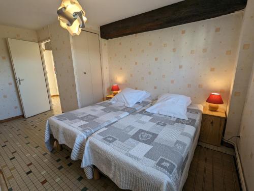 1 dormitorio con 1 cama, 2 mesas y 2 lámparas en Gîte Jouy-le-Potier, 3 pièces, 4 personnes - FR-1-590-54, en Jouy-le-Potier