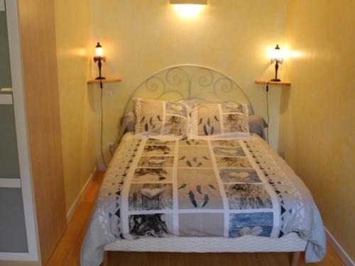 uma cama num quarto com duas luzes na parede em Gîte Le Menil, 1 pièce, 2 personnes - FR-1-589-164 em Le Ménil