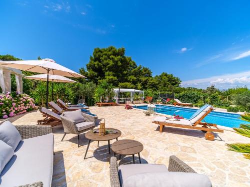 a patio with chairs and a swimming pool at Seaside luxury villa with a swimming pool Mirca, Brac - 16183 in Supetar