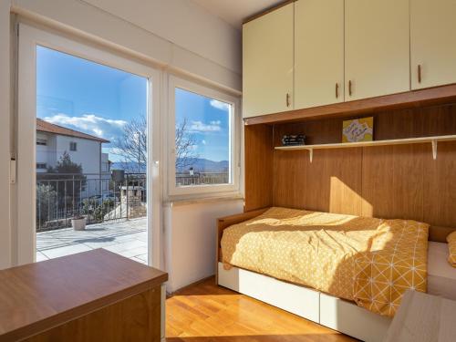 ein Schlafzimmer mit einem Bett und einem großen Fenster in der Unterkunft Apartments with a parking space Kostrena, Rijeka - 14285 in Kostrena