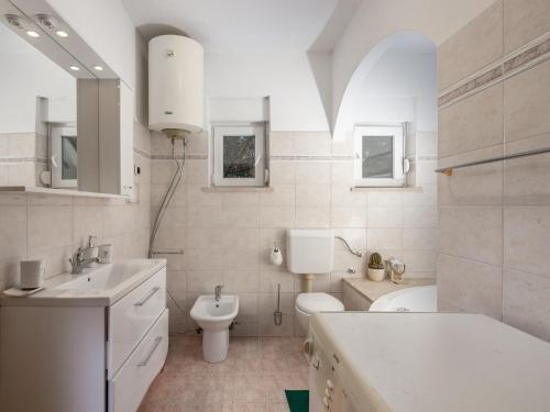 ein weißes Bad mit einem WC und einem Waschbecken in der Unterkunft Apartments with a parking space Kostrena, Rijeka - 14285 in Kostrena