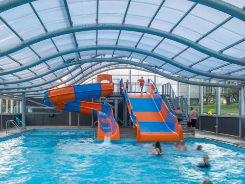 a pool with a water slide and people in the water at Blue Lake Holiday Park in Mount Gambier