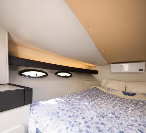 a bedroom with a bed and two lights on the wall at Alojamiento en Barco Voralamar in Valencia