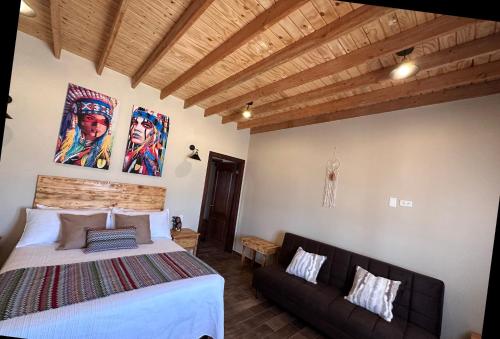 a bedroom with a bed and a couch at Grape Valley Old West Cabins in Ensenada