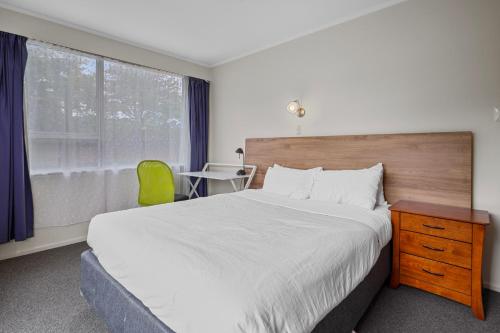 a bedroom with a bed and a desk and a window at Matipo Retreat - Christchurch Holiday Home in Christchurch