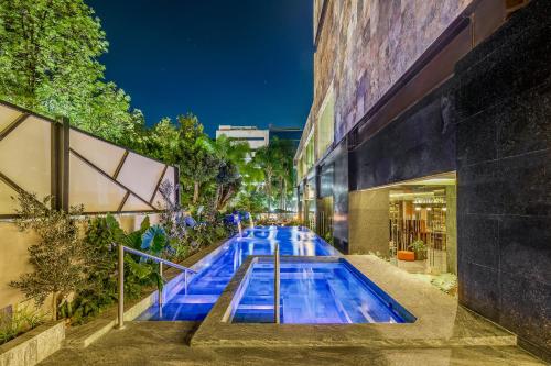 a swimming pool in front of a building at night at Grand Fiesta Americana Guadalajara Country Club in Guadalajara