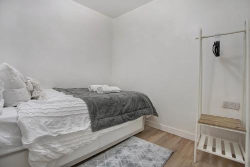 a white bedroom with a bed and a mirror at Cozy 1-Bed Apartment Close to Lcy & Excel in London