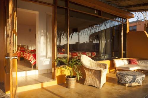een balkon met stoelen, een bank en een tafel bij LA PUNTA LOBITOS HOTEL in Talara