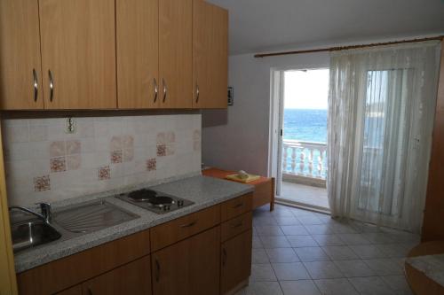 a kitchen with a sink and a view of the ocean at Apartments by the sea Milna, Hvar - 22619 in Hvar