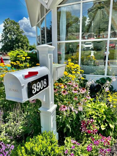 a clock in a garden with flowers in front of a building at The Villas on Lake George in Diamond Point