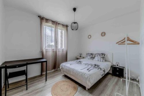 Habitación blanca con cama y escritorio en Appartement de 3 chambres avec terrasse amenagee et wifi a Gradignan, en Gradignan