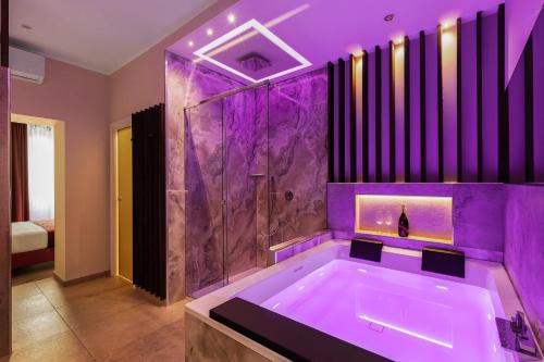 a purple bathroom with a tub and a shower at AlbaDea Déco&Jacuzzi in Rome
