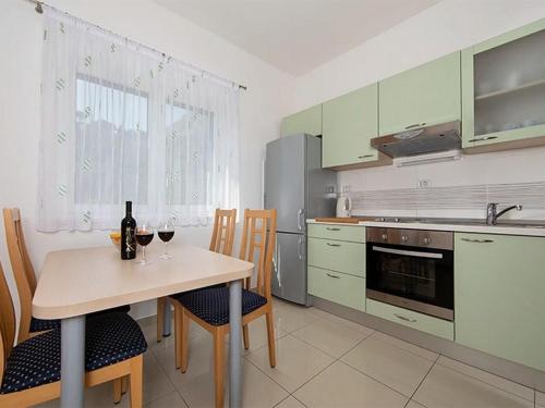 una cucina con tavolo e 2 bicchieri di vino di Apartments by the sea Igrane, Makarska - 17292 a Igrane