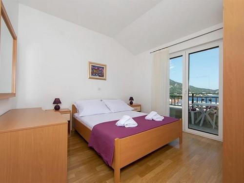 una camera da letto con un letto e due asciugamani di Apartments by the sea Igrane, Makarska - 17292 a Igrane