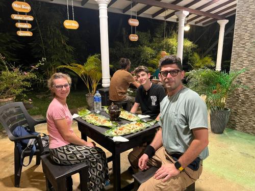 a group of people sitting at a table with pizza at Nature World Udawalawe in Udawalawe