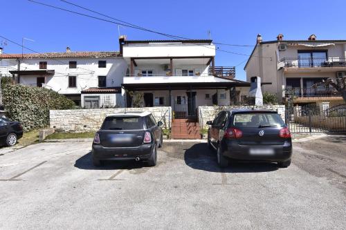 two cars parked in a parking lot in front of a house at Apartments and rooms by the sea Zambratija, Umag - 22685 in Savudrija