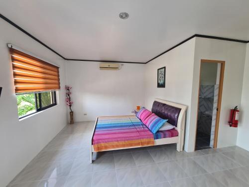 a bedroom with a bed with a colorful blanket at H&P Inn in Pandan