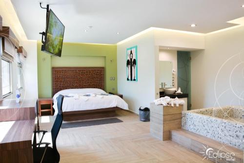 una camera con letto, TV e vasca di HOTEL ECLIPSE TOLUCA a Toluca