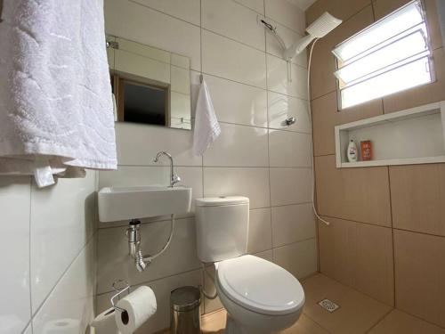 La salle de bains est pourvue de toilettes, d'un lavabo et d'un miroir. dans l'établissement Sobrado bem próximo ao Aeroporto, à Guarulhos
