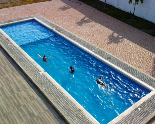 een zwembad met drie personen in het water bij Casa vacacional disfruta junto al mar in Manta
