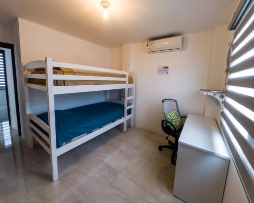 Cette chambre dispose de lits superposés, de 2 lits superposés et d'un bureau. dans l'établissement Casa vacacional disfruta junto al mar, à Manta