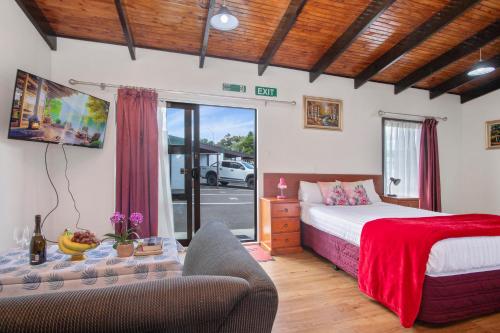 - une chambre avec un lit, un canapé et une table dans l'établissement Grange Motel, à Auckland