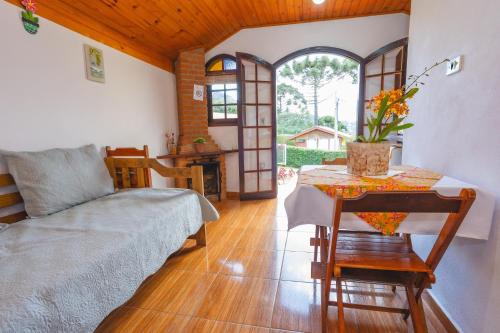 uma sala de estar com uma cama e uma mesa com uma mesa de sidx em Chalés Pedra do Baú em São Bento do Sapucaí