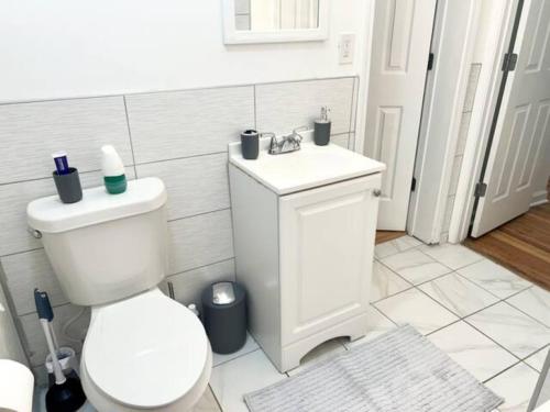 a white bathroom with a toilet and a sink at King Deluxe Suite Room 2 in Atlanta