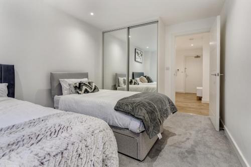 Un dormitorio con dos camas y un espejo. en 1 Bed Sleeps 3 Free Parking Wifi, en Slough