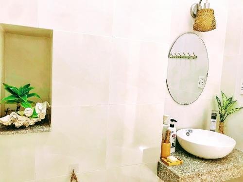 y baño con lavabo blanco y espejo. en Nạp Homestay, en Kinh Dinh