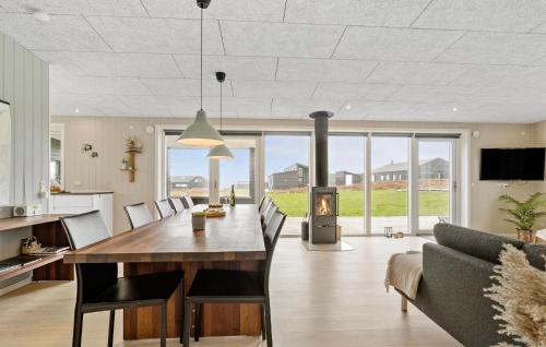 a kitchen and living room with a dining table and a fireplace at Three-Bedroom Holiday Home In Haderslev in Haderslev