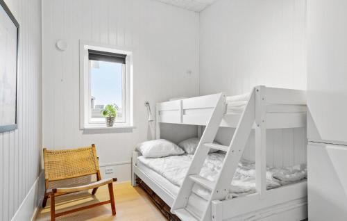 ハザスレウにあるAmazing Home In Haderslev With Kitchenの小さな部屋(椅子付)の白い二段ベッド1台分です。