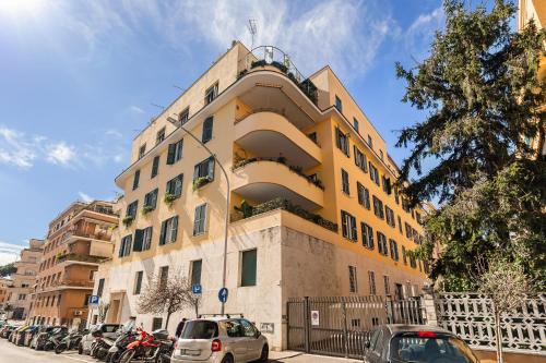 a yellow building with cars parked in front of it at AlbaDea Déco&Jacuzzi in Rome