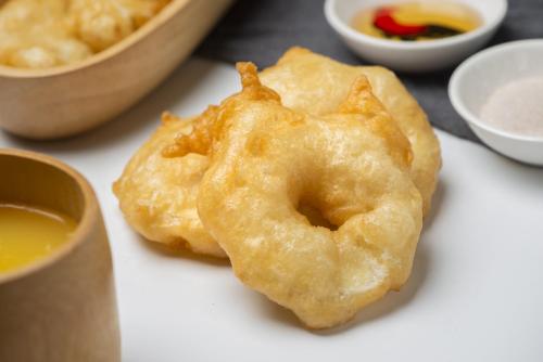 Dois donuts fritos sentados numa mesa com molhos. em Shangri-La Changchun em Changchun