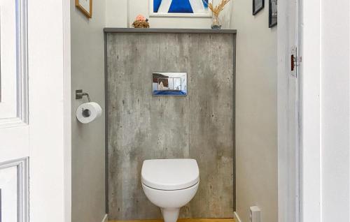 a bathroom with a toilet and a wooden door at Awesome Home In Stavang With Kitchen in Stavang