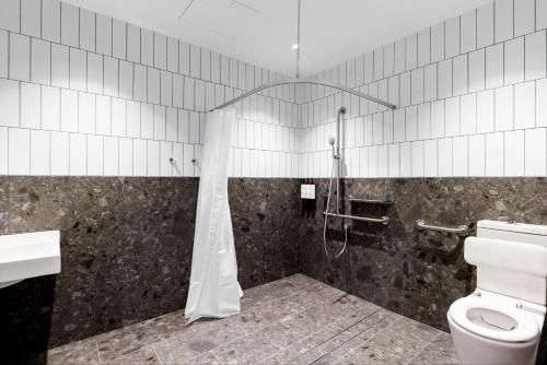 a bathroom with a shower and a toilet at Quest Woolooware Bay in Cronulla