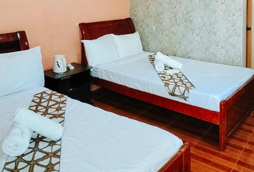 a hotel room with two beds with white sheets at RedDoorz @ Hilarion's Farm Majayjay, Laguna in Majayjay