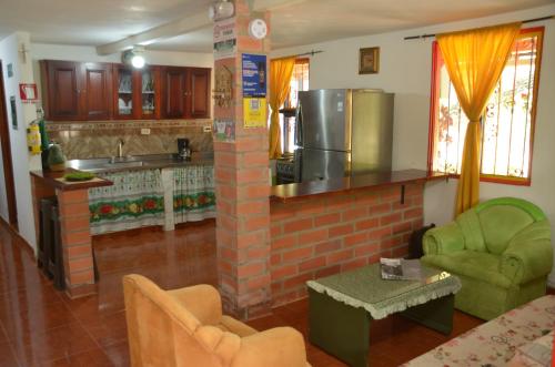 Casa de campo Jardín في خاردين: غرفة معيشة مع مطبخ بجدار من الطوب
