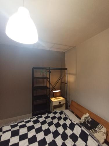 ein Schlafzimmer mit einem Bett mit einem karierten Boden in der Unterkunft Chambre Calme meublé proche aéroport rocade in Pessac