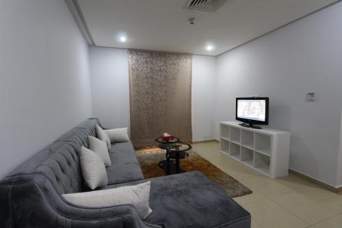 a living room with a couch and a television at New flk in Kuwait