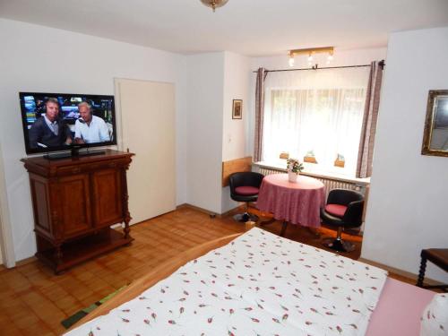 Cette chambre dispose d'une télévision, d'une table et d'un lit. dans l'établissement Appartement Zeitz Ramsau, à Ramsau bei Berchtesgaden