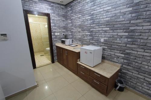 a kitchen with a brick wall and a small refrigerator at New flk in Kuwait