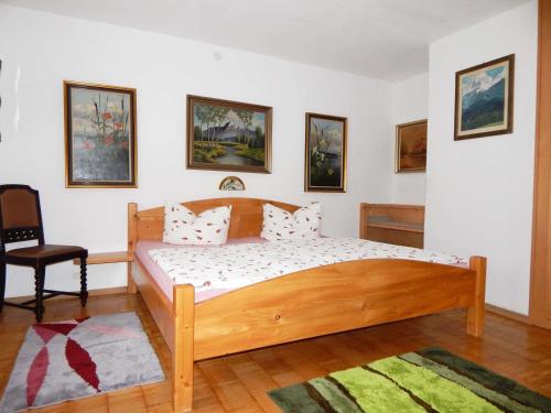 ein Schlafzimmer mit einem Holzbett und einem Stuhl in der Unterkunft Appartement Zeitz Ramsau in Ramsau bei Berchtesgaden