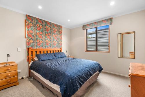 a bedroom with a bed and a dresser and a window at Hāwea Delight - Lake Hāwea Holiday Home in Lake Hāwea